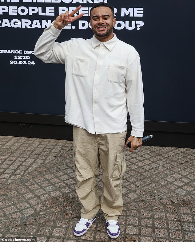 The event's host, Wes, wore a long-sleeved off-white shirt with khaki cargo pants and white and purple sneakers and held a microphone.