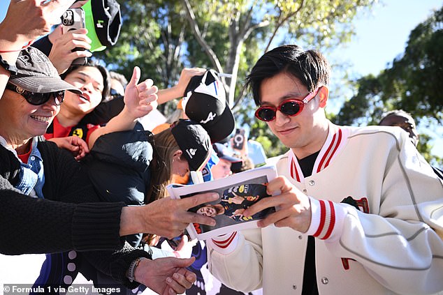 Zhou Guanyu is pictured signing autographs in his $5,100 Christian Dior jacket