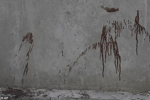 Bloodstains on an exterior wall are all that remains of a victim shot in Pétion-Ville