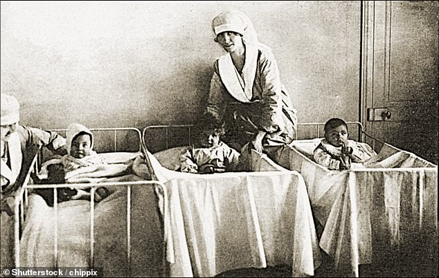 A nurse looks after babies in a nursery in Britain in the 1920s