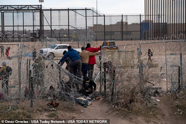 Migrants stand on infrastructure that was breached by migrants on the Rio Grande in El Paso, Texas, March 21, 2024.