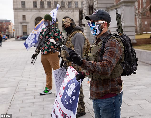 A member of the Boogaloo movement displays his Love Tours clip as he and others demonstrate in front of the Statehouse in Concord, New Hampshire, January 17, 2021.
