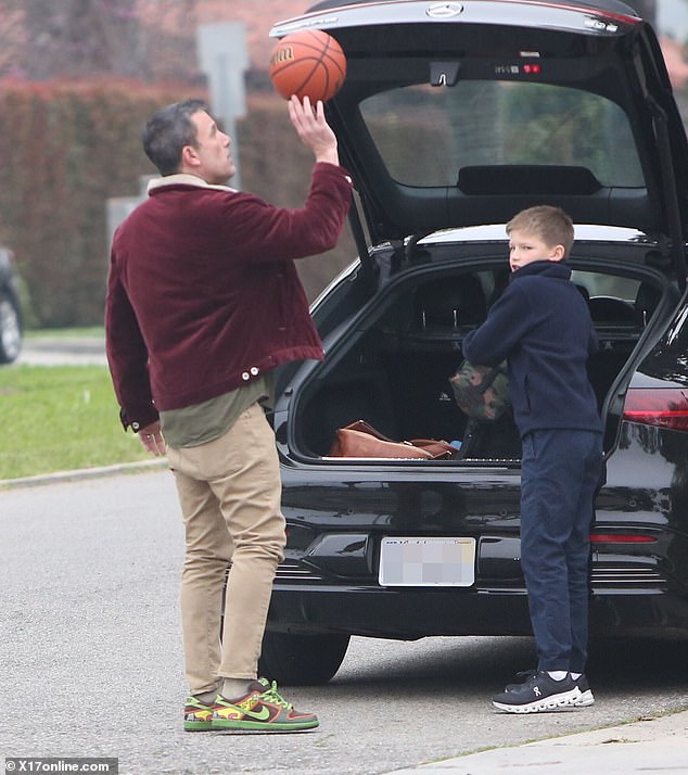 Oscar winner Argo was spotted twirling the basketball on his fingers in front of the open hatch of his black Mercedes.