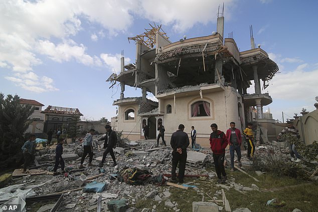 Palestinians look at house destroyed in Israeli airstrike in Rafah