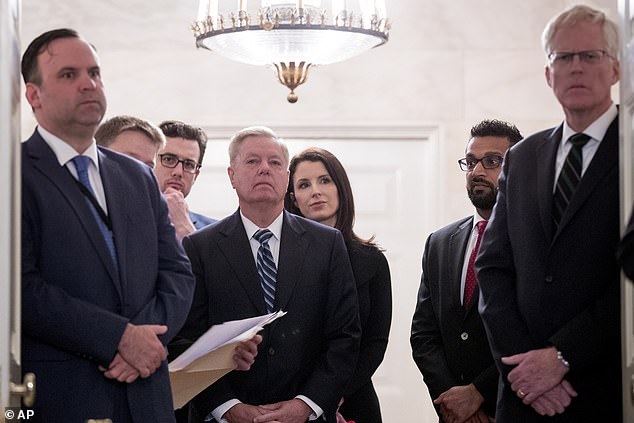 Christopher Miller (right) looks on with Kash Patel (second from right), Sen. Lindsey Graham (center) and former White House social media director Dan Scavino (left) as Trump speaks in the Diplomatic Room on 27 October 2019