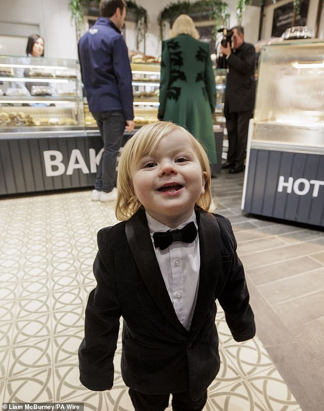 The toddler wore a small tuxedo as he smiled for the photos, moving closer to the camera.