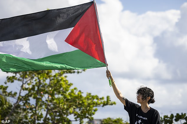 A protester waves a Palestinian flag during a protest against Vice President Kamala Harris' visit to Puerto Rico