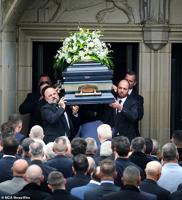 Pallbearers carry Mr Latorre's ornate coffin from St Monica's Cathedral