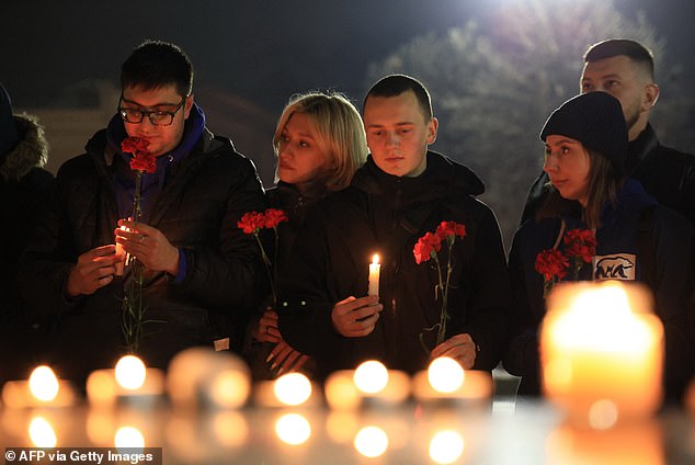 People lay flowers and light candles in memory of the victims of the concert gun attack in Moscow