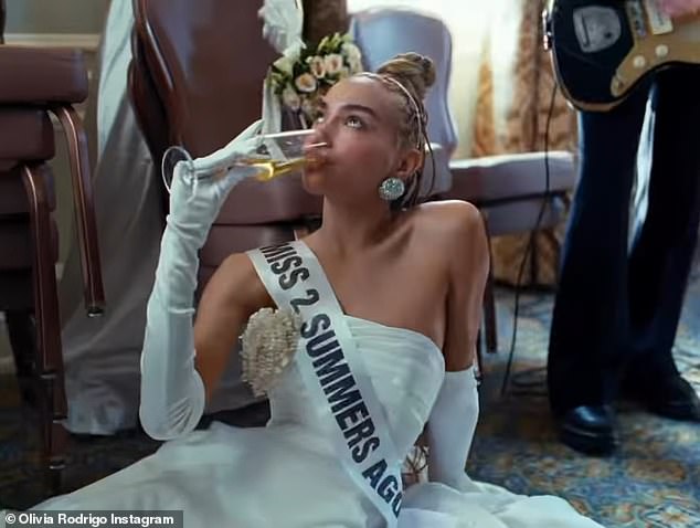 At this point in the preview clip, the edit begins to pick up and includes another young lady wearing a 'Miss 2 Summers Ago' sash who is seen lying on the floor drinking champagne