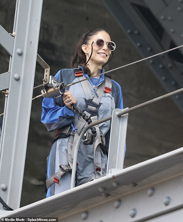 Bethenny smiled nervously as she walked along the bridge while securely attached to a harness