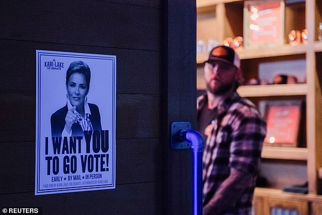 A 'Kari Lake for Senate' poster is posted on the door at a watch party hosted by her campaign at the Foley Ranch Country Bar in Phoenix, Arizona on March 19