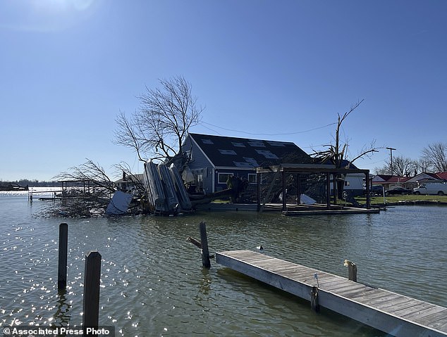 A boat lies upside down in a tree on Orchard Island in Russells Point, Ohio, on Saturday, March 16, 2024.
