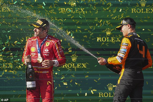 Britain's Lando Norris (right) is shown spraying Sainz with champagne after finishing third.