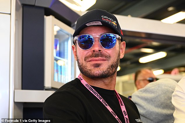 Efron kept it casual in a black long-sleeved T-shirt and opted for a pair of stylish sunglasses as he looked around the Oracle Red Bull Racing garage.