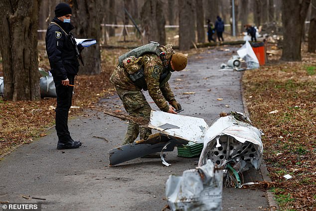 Police officers inspect a part of a Russian Kh-55 cruise missile, intercepted during a missile attack, amid Russia's attack on Ukraine, in a park in kyiv on March 24.