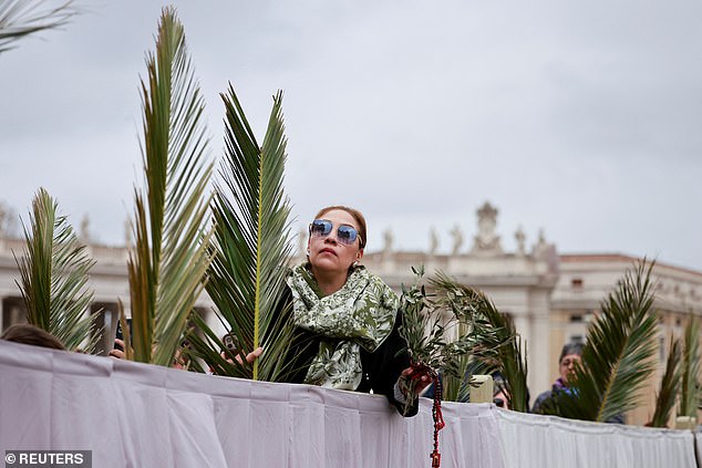 A woman holding a palm branch during Pope Francis' mass at the Vatican today