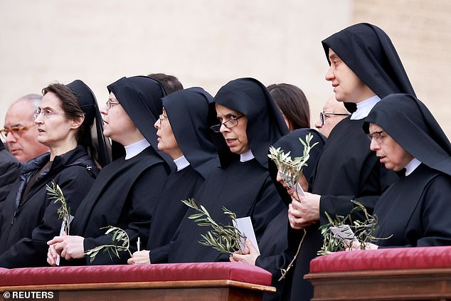Nuns hold olive branches as Pope Francis celebrates Palm Sunday Mass in St. Peter's Square at the Vatican.