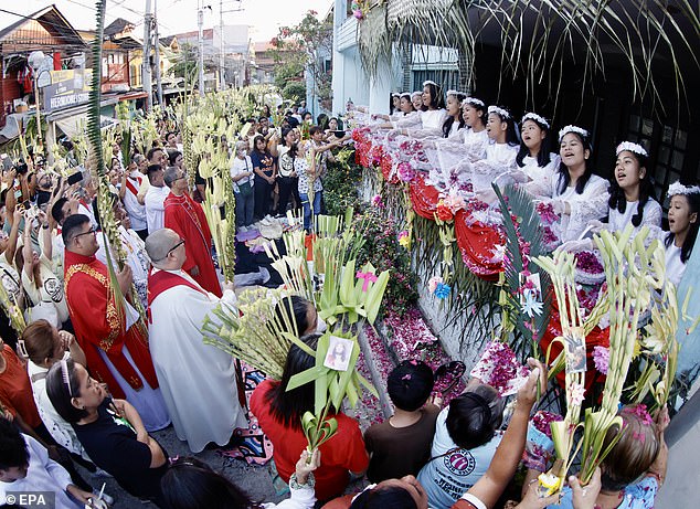 Children in the Philippines throw flower petals to worshipers during a procession to commemorate Palm Sunday in the city of Las Piñas.
