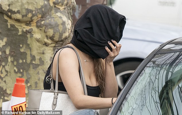 A woman left Andolaro's property in Flushing, Queens, earlier this week covering her face.