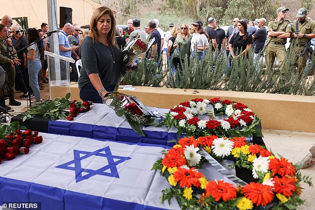 More than five months after the Oct. 7 Hamas terrorist attacks, the kibbutz of nearly 800 residents is a ghost town. (Mourner at the funeral of the murdered victims in Kfar Aza)