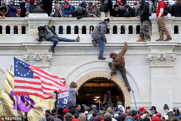 Protesters climb the side of the US Capitol building on January 6, 2021