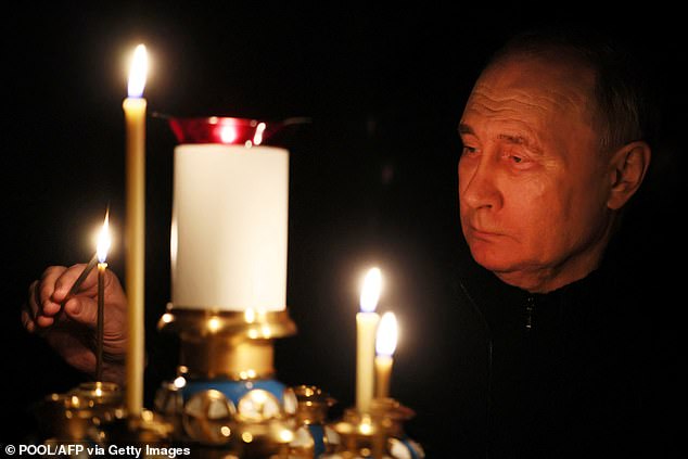Vladimir Putin lights a candle during his visit to a church in the Novo-Ogaryovo state residence on March 24 as the country observes a national day of mourning after the massacre.