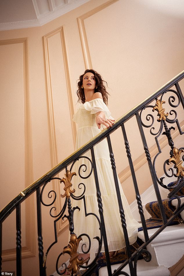One ethereal shot saw her descend a staircase in a flowing white dress, a semi-sheer tiered skirt and ruffled sleeves.