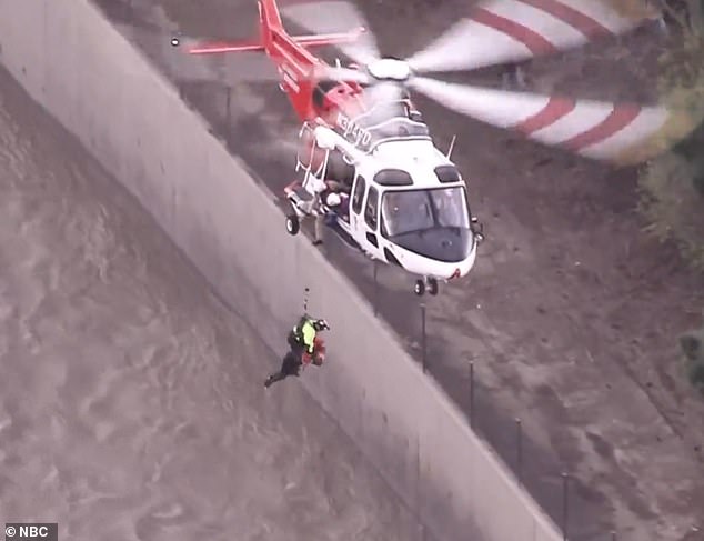 On the other side of the overpass, a rescuer hurriedly descended from an LAFD helicopter, hoping to intercept the woman.