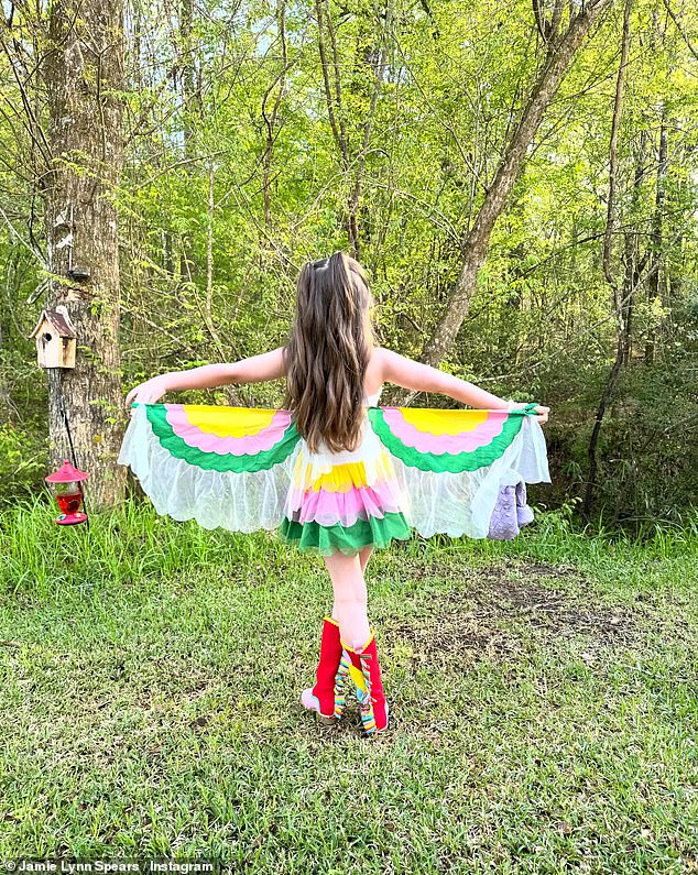 In other snapshots she showed her dress with rainbow colors and parrots on the front and wings. Ivey also wore red and pink cowboy boots and posed with her father in two of the images.