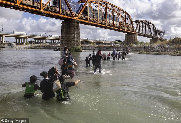 Asylum seekers cross the Rio Grande from Mexico into the United States on September 30, 2023 in Eagle Pass, Texas.