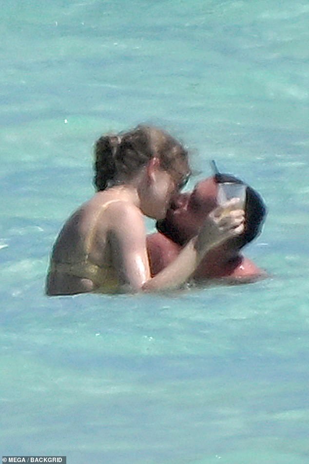 The loved-up couple, who have been dating since September, kiss in the ocean waters while on vacation.