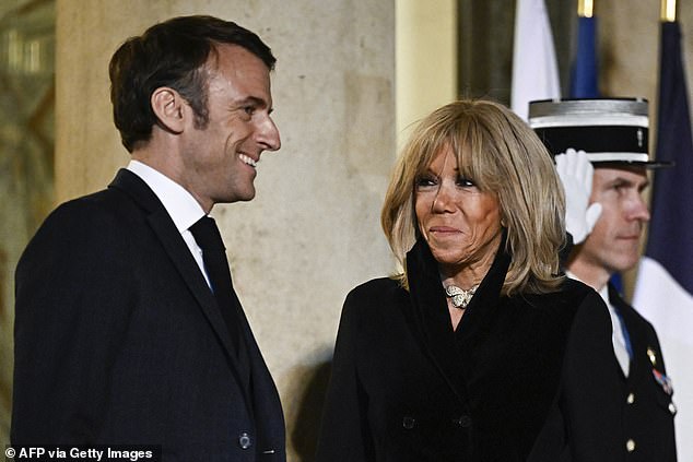 French President Emmanuel Macron (L) and his wife Brigitte Macron wait to receive the President of Lithuania and his wife at the Elysee Presidential Palace ahead of their meeting in Paris on March 12, 2024.