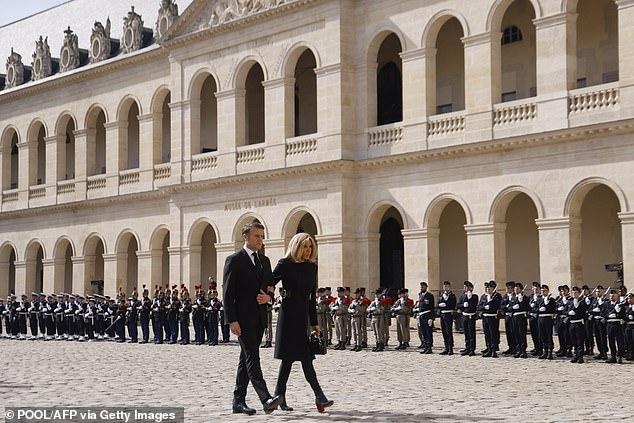 French President Emmanuel Macron (L) and his wife Brigitte Macron walk while attending a "national tribute" Ceremony for the late French politician and admiral, Philippe de Gaulle, son of Charles de Gaulle, at the Hotel des Invalides in Paris on March 20, 2024.