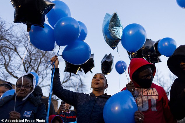 Alicia Perkins, center, aunt of Jayden Perkins' father, holds balloons outside Perkin's Chicago home in a tribute to Jayden, who was murdered.