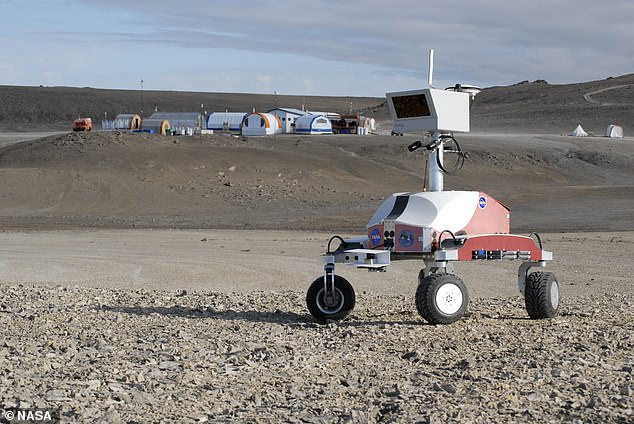 A rover and the Haughton Mars Research Project base camp in Haughton Crater