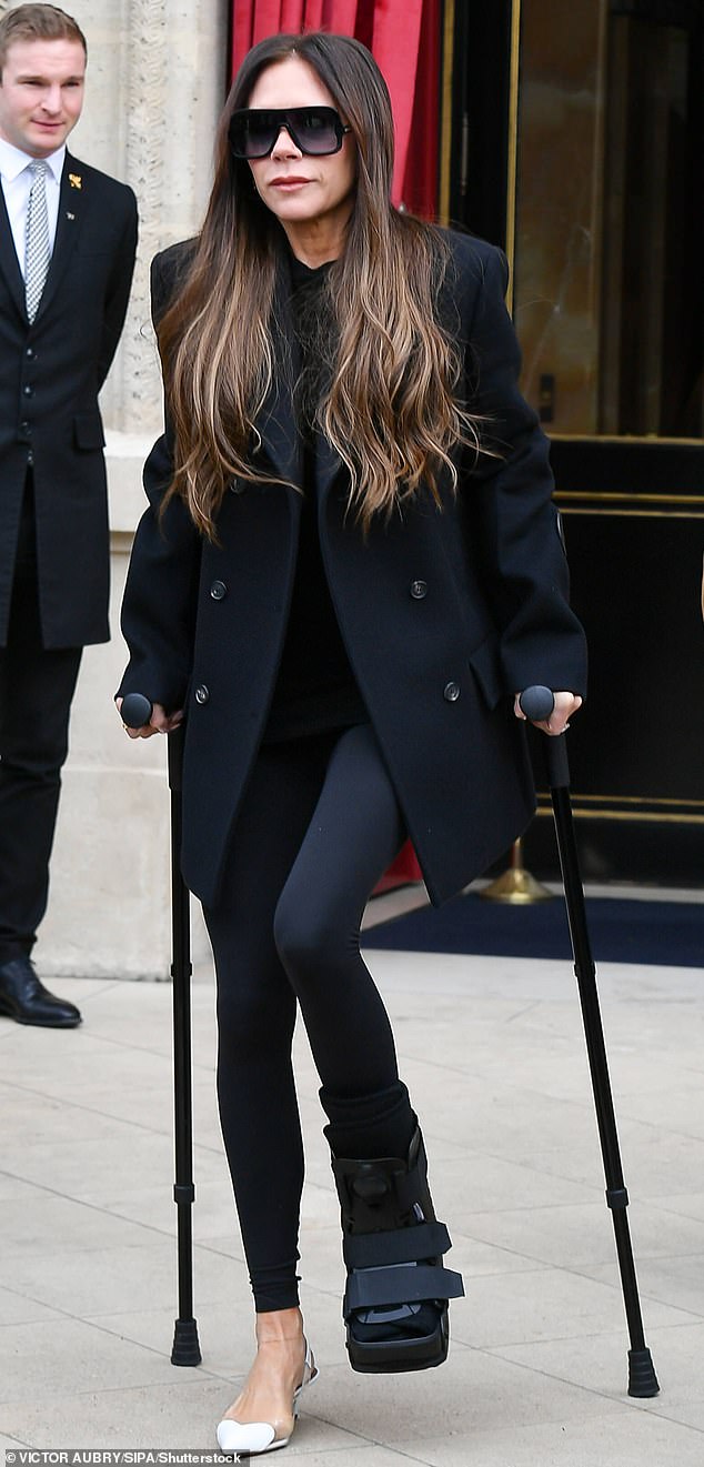 The fashion designer has one foot in a medical boot and the other in a stiletto heel while in Paris earlier this month.