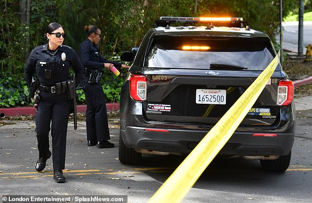 Police officers monitor the scene at Diddy's mansion in Holmby Hills.