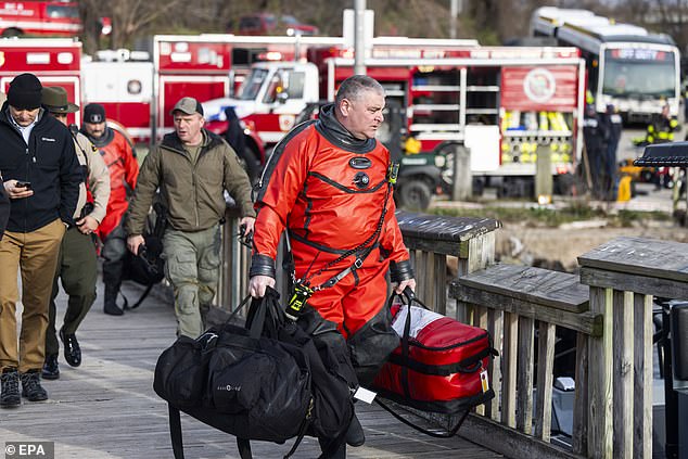 Rescue personnel gather on the bank of the Patapsco River to rescue those affected