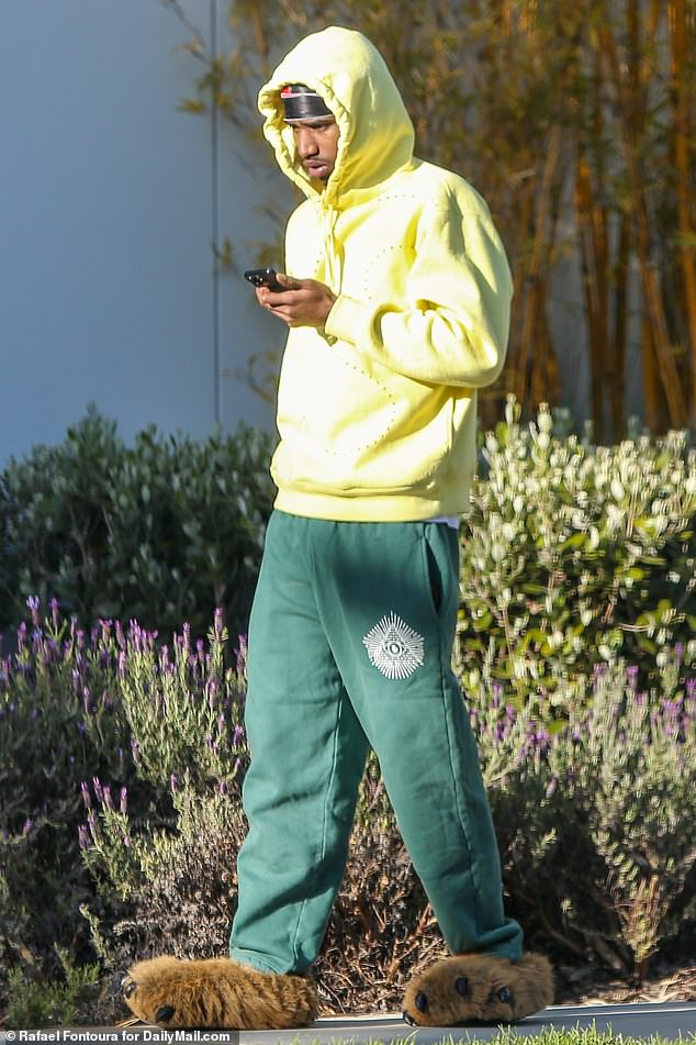 King, 25, was seen walking outside the Los Angeles mansion wearing a yellow hoodie and sweatpants with the Illuminati logo, as well as furry slippers.