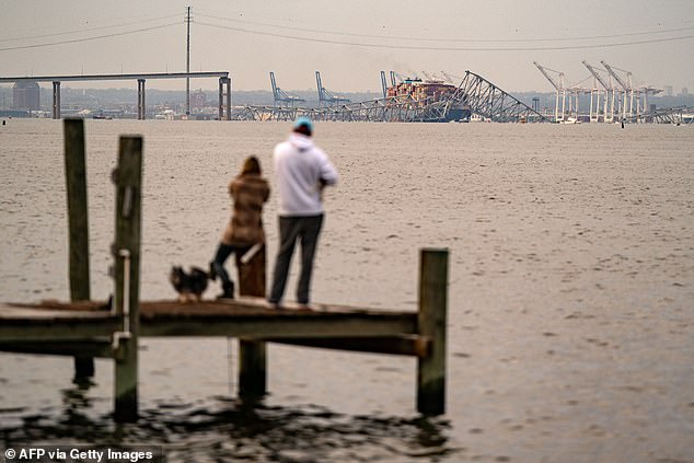 People look toward the Francis Scott Key Bridge after it collapsed after the Singapore-flagged container ship Dali collided with it along the Patapsco River on March 26.