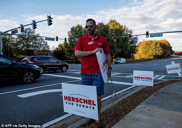 Huffman placing Walker signs outside an event in Kennesaw, Georgia