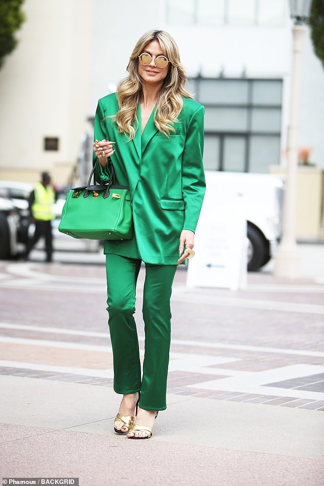 The runway queen, 50, donned a bright jade-colored suit and matching bag as she walked onto the set.