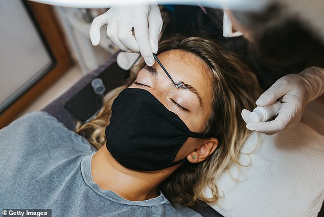 The process neutralizes the bonding of the hair and then allows the eyebrow artist to reshape it with saran wrap to keep the hairs in place (stock image)