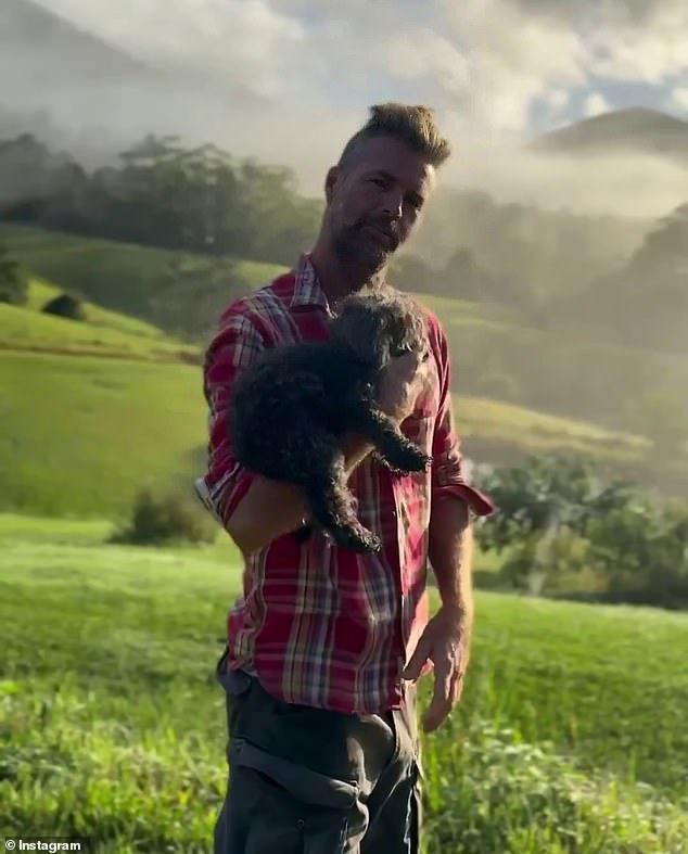In a video shared by his wife Nicola Watson, the former My Kitchen Rules judge showed off his flowing mullet that tapers into a rat tail as he cuddled up to his dog while enjoying the extensive countryside views at his home.