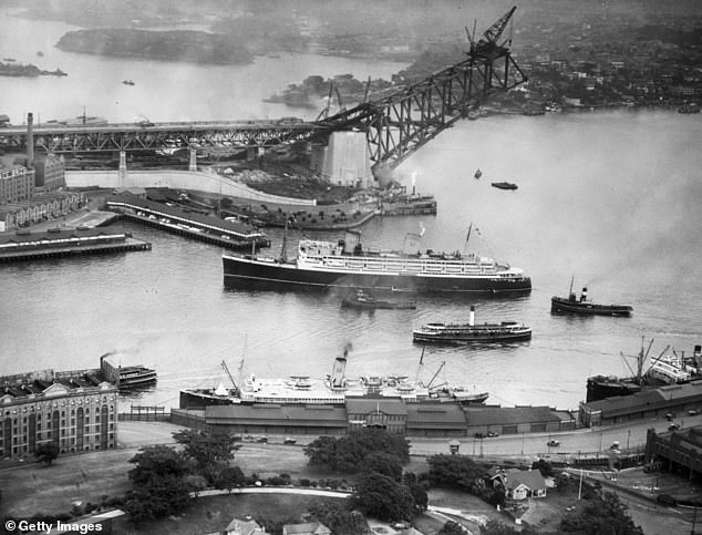 At each end of the Sydney Harbor Bridge are two pairs of 89-metre-high towers that were not part of the original design. Granite blocks were later added to assure the public that they would not fall. The Sydney Harbor Bridge appears in 1930 under construction.
