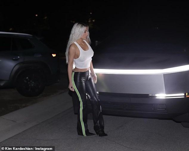The Kardashian star continued to show off her platinum blonde hair, which cascaded over her shoulder in long, wavy strands, while exposing her dark mid-section roots.