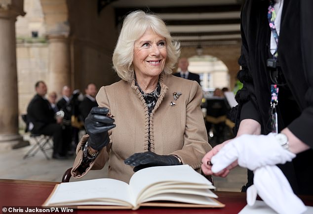 Camilla signs the guest book at the Old Market Hall during her trip to Shrewsbury