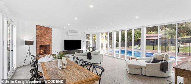 Highlights include a large living room with polished concrete floors, walls of glass and a fireplace, which opens to an entertaining terrace and pool area. (In the photo)