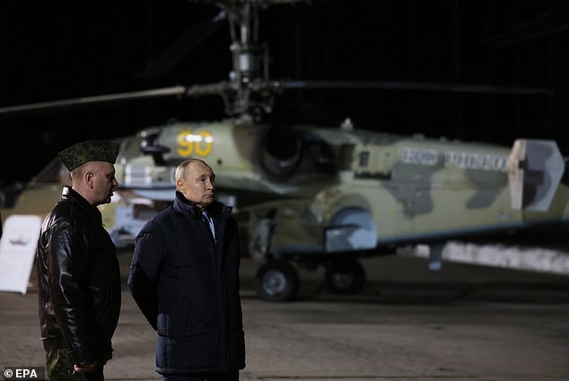 Russian President Vladimir Putin (2-L) talks with Hero of Russia, head of the air weapons training and tactical training center, Alexander Karamyshev (L)